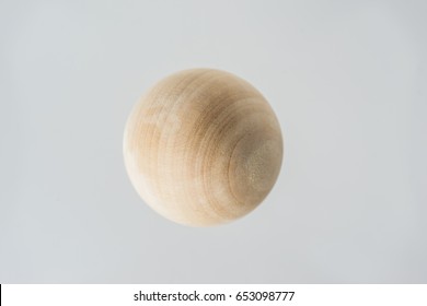 Surreal design concept - real wooden ball float on grey background like the planet on the universe