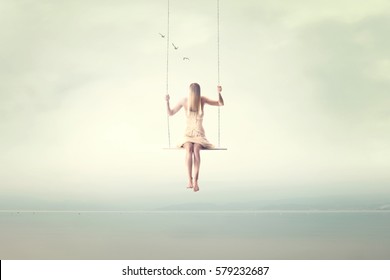 Surreal Fantastic Woman Swings On A Seesaw In The Air