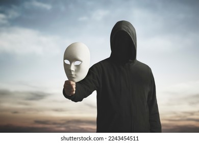 surreal image of a man with obscured face showing his mask, concept of playing with the different personalities of one's character - Shutterstock ID 2243454511