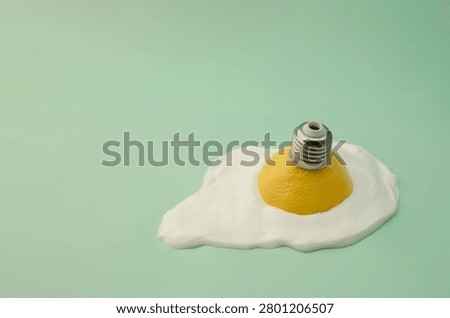 Surreal minimalist composition featuring a lemon light bulb emerging from a fried egg shape, symbolizing creativity, innovation and unconventional thinking