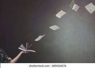 Surreal Moment Of Pages Flying From A Book Held By A Woman