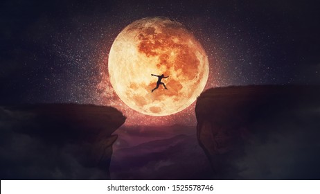 Surreal scene, self overcome concept, as determined man jump over a chasm obstacle. Way to win and success over starry night with full moon background. Motivation for achieving goals.