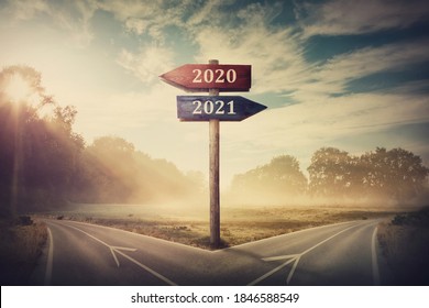 Surreal scene with a split road and signpost arrows showing two different courses, left and right, past and future, old 2020 and the new 2021 year direction to choose. Life decision, choice concept. - Shutterstock ID 1846588549