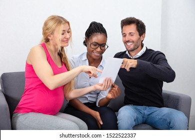 Surrogate Mother Showing Ultrasound Baby Images To Young Couple