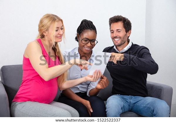 Surrogate Mother Showing Ultrasound Baby Images To\
Young Couple