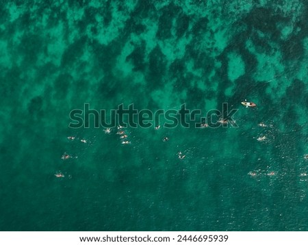 Surrounding Islands of Koh Kham, Thailand green lush tropical island in a blue and turquoise sea with islands in the background and clouds with sun beams shining through, drone aerial photo