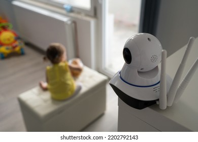 Surveillance camera baby monitor at home monitoring small child while playing in room childhood family protection parenthood concept