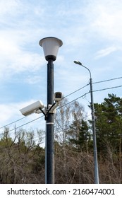 Surveillance cameras mounted on a lamppost at the side of a forest road. security cctv camera. Security in the city. Hidden filming of what is happening. Modern technologies and equipment