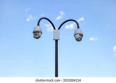 Surveillance Cctv (closed Circuit Television) Camera Installed In Public Park On Blue Sky Background For Protection Against Crime, Observation Of People, Control Of Observance Of Public Order.