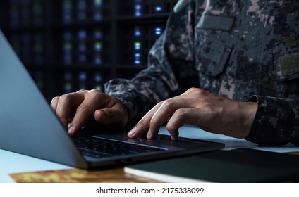 Surveillance and control of opposing information concept, Soldier in camouflage uniform working on laptop for Information Operation.
