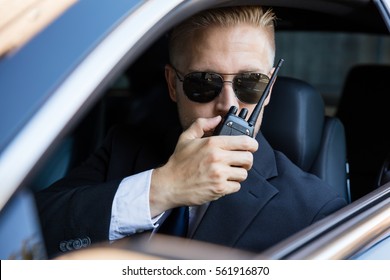 Surveillance Man Sitting Inside Car Talking On Walkie Talkie