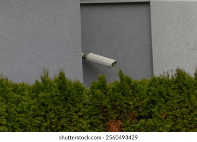 A surveillance security camera is mounted securely on the side of a tall building, watching over the area for safety and monitoring purposes
