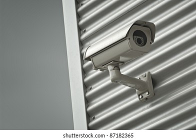 surveillance security camera on red wall