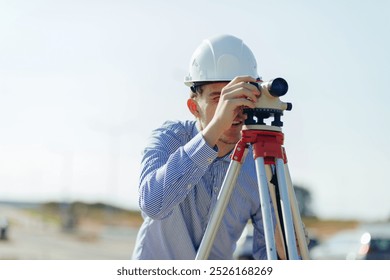 Survey engineer working with operating level survey cameras on construction site.