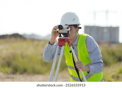 Survey engineer working with operating level survey cameras on construction site.