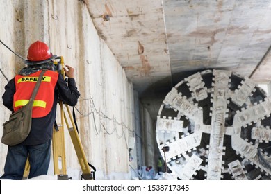 Survey Staff Wear A Safety Junction To Look Through A Theodolite At The Underground Tunnel Construction,Transport Pipeline By Tunnel Boring Machine(TBM) Method For Electric Train Subway.