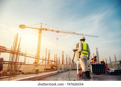 Surveyor builder Engineer with theodolite transit equipment at construction site outdoors during surveying work - Shutterstock ID 747626554