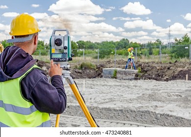 Surveyor engineer is measuring level on construction site. Surveyors ensure precise measurements before undertaking large construction projects.