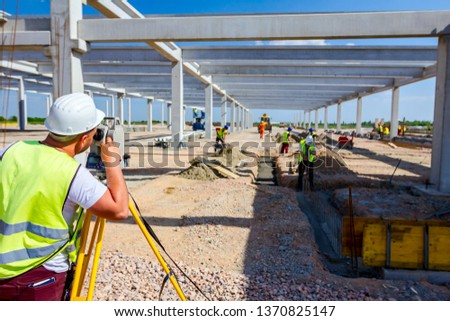 Surveyor engineer is measuring level on construction site. Surveyors ensure precise measurements before undertaking large construction projects.