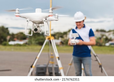 A Surveyor Operating A Drone To Conduct Topographic RTK Or PPK Aerial Survey Or Photography Of A Plot Of Land.