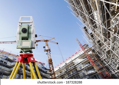 surveyors measuring instrument, close-ups, large super-wide construction site in background