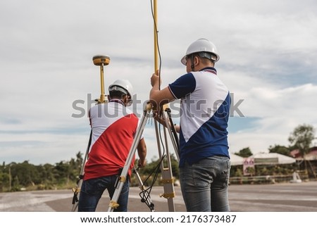 Surveyors setting up a pair of Global Navigation Satellite System or GNSS Receiver. Real-time kinematic or RTK geodetic surveying equipment used in the field.