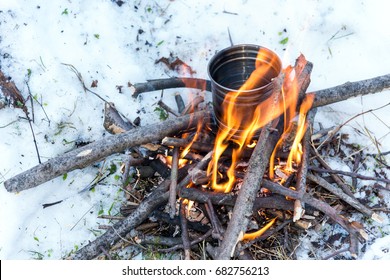 Survival in the winter - boiling water for tea over small campfire