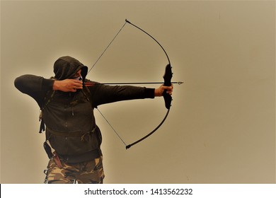 Survivalist Shooting With Bow And Arrow