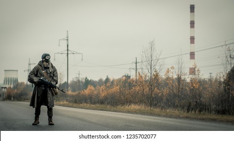 Survivor Soldier In Gas Mask And With Russian Assault Rifle Walking In The Danger Radioactive Zone Of Wastelands. Post Apocalypse. Nuclear War.