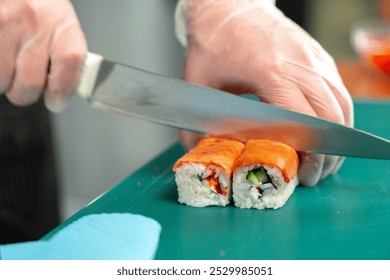 Sushi chef skillfully slicing fresh sushi rolls with precision at a bustling restaurant kitchen - Powered by Shutterstock