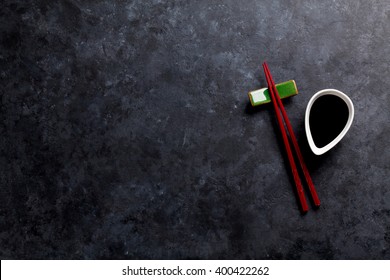 Sushi chopsticks and soy sauce on stone table. Top view with copy space