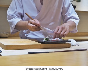 sushi master decorating fish plate, japanese food