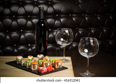 sushi mix served dinner with wine on table at restaurant, evening date in cosy room, food photography