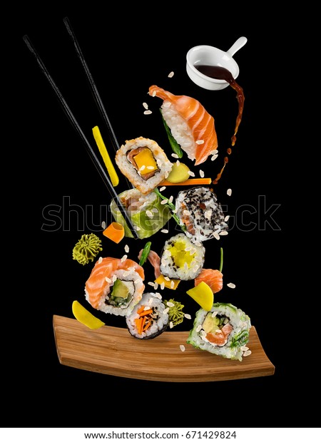 Sushi\
pieces placed between chopsticks, separated on black background.\
Popular sushi food. Very high resolution\
image