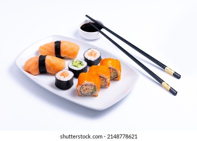 Sushi plate on white background. Makizushi. Delicious sushi rolls on white plate with chopsticks and wasabi. Maki - Powered by Shutterstock