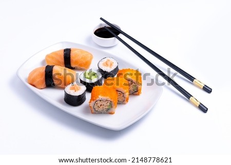 Sushi plate on white background. Makizushi. Delicious sushi rolls on white plate with chopsticks and wasabi. Maki