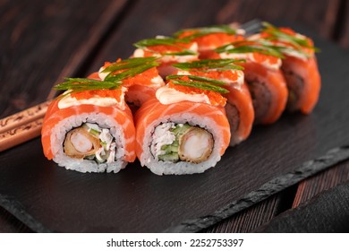 Sushi roll philadelphia with crab and cucumber and cream cheese, caviar on black background close-up. Sushi menu. Japanese food concept - Powered by Shutterstock