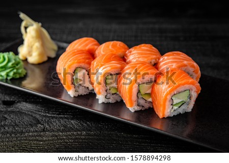 Sushi roll (Philadelphia) with salmon, smoked eel, avocado, cream cheese on black background. Sushi menu. Japanese food. Stockfoto © 