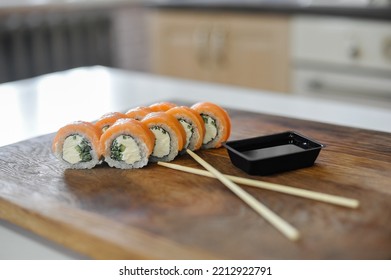 Sushi Roll With Salmon, Avocado, Cucumber And Wasabi On Wooden Board