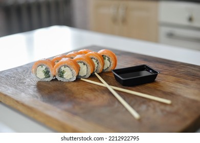 Sushi Roll With Salmon, Avocado, Cucumber And Wasabi On Wooden Board