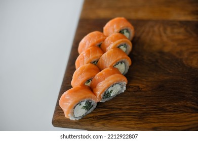 Sushi Roll With Salmon, Avocado, Cucumber And Wasabi On Wooden Board