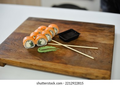 Sushi Roll With Salmon, Avocado, Cucumber And Wasabi On Wooden Board