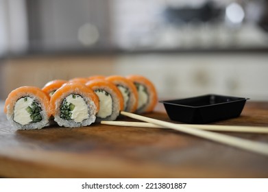 Sushi Roll With Salmon, Avocado, Cucumber On Wooden Board