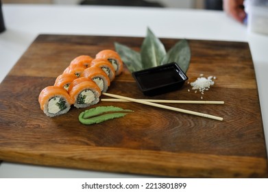 Sushi Roll With Salmon, Avocado, Cucumber And Wasabi On Wooden Board