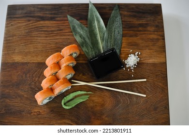 Sushi Roll With Salmon, Avocado, Cucumber And Wasabi On Wooden Board