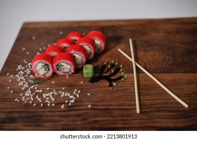 Sushi Roll With Salmon, Avocado, Cucumber And Wasabi On Wooden Board