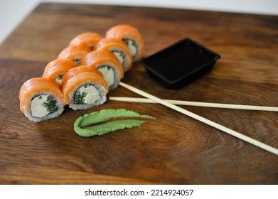 Sushi Roll With Salmon, Avocado, Cucumber And Wasabi On Wooden Board