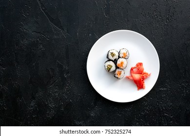 Sushi Roll With Salmon And Avocado On Plate On Black Background Top View.