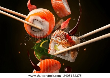 Sushi Rolls in assortment on the air. Concept of levitation. black background, horizontal view.
