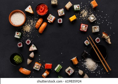 Sushi and rolls background, frame on black, top view. Colorful japanese restaurant food set